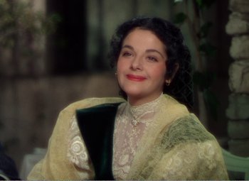 Movie still from “The Great Caruso” (1951), directed by Richard Thorpe – A woman in a yellow dress holding a green vase; Close Up shot, High angle