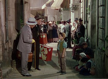 Movie still from “The Great Caruso” (1951), directed by Richard Thorpe – A group of men standing around a sidewalk; Wide shot, High angle