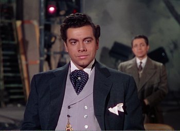 Movie still from “The Great Caruso” (1951), directed by Richard Thorpe – A man in a suit and tie standing next to another man in a suit and tie; Medium shot, Low angle