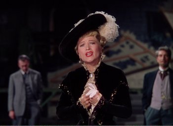 Movie still from “The Great Caruso” (1951), directed by Richard Thorpe – A woman wearing a black hat and a black jacket; Medium shot, Over the shoulder angle