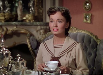 Movie still from “The Great Caruso” (1951), directed by Richard Thorpe – A woman sitting at a table holding a tea cup; Medium shot, High angle