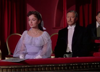 Movie still from “The Great Caruso” (1951), directed by Richard Thorpe – A man and a woman sitting on a red bench; Medium shot, High angle