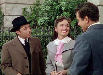 Movie still from “The Great Caruso” (1951), directed by Richard Thorpe – A group of people standing next to each other on a street; Medium shot, Over the shoulder angle