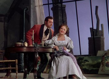 Movie still from “The Great Caruso” (1951), directed by Richard Thorpe – A man and a woman sitting at a table; Medium shot, Low angle