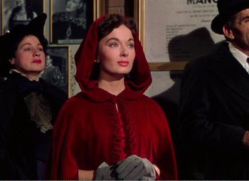 Movie still from “The Great Caruso” (1951), directed by Richard Thorpe – A woman wearing a red cape and holding a glove; Medium shot, Low angle