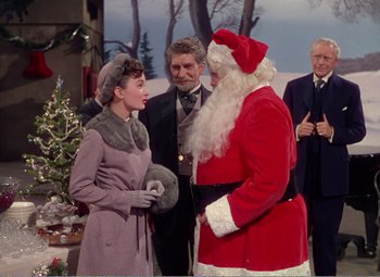 Movie still from “The Great Caruso” (1951), directed by Richard Thorpe – A man dressed as santa claus and a woman dressed as audrey hepburn; Medium shot, Over the shoulder angle