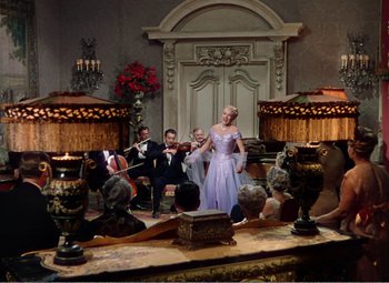 Movie still from “The Great Caruso” (1951), directed by Richard Thorpe – A group of people sitting in a room; Wide shot, Low angle