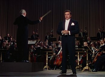 Movie still from “The Great Caruso” (1951), directed by Richard Thorpe – A man standing in front of an orchestra; Medium shot, Low angle