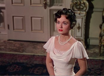 Movie still from “The Great Caruso” (1951), directed by Richard Thorpe – A woman in a white dress with a pearl necklace; Medium shot, Over the shoulder angle