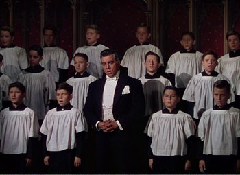Movie still from “The Great Caruso” (1951), directed by Richard Thorpe – A man standing in front of a group of young boys; Medium shot, Low angle