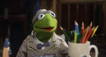 Movie still from “The Great Muppet Caper” (1981), directed by Jim Henson – A stuffed animal dressed as kermit the frog; Close Up shot, Over the shoulder angle