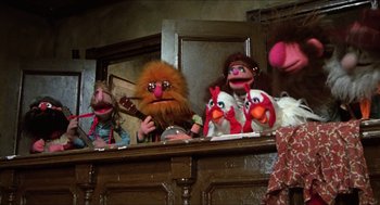 Movie still from “The Great Muppet Caper” (1981), directed by Jim Henson – A group of people sitting around a table with puppets; Wide shot, Low angle