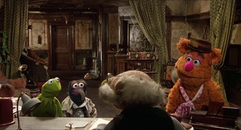 Movie still from “The Great Muppet Caper” (1981), directed by Jim Henson – A group of people sitting around a table with stuffed animals on it; Wide shot, High angle