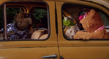 Movie still from “The Great Muppet Caper” (1981), directed by Jim Henson – A group of stuffed animals sitting in the back of a yellow van; Wide shot, High angle