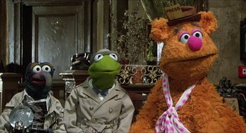 Movie still from “The Great Muppet Caper” (1981), directed by Jim Henson – Two stuffed animals sitting next to each other in a living room; Medium shot, Over the shoulder angle