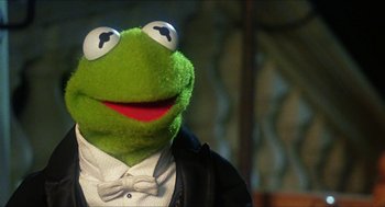 Movie still from “The Great Muppet Caper” (1981), directed by Jim Henson – The head of kermit the frog wearing a tuxedo; Close Up shot, Low angle