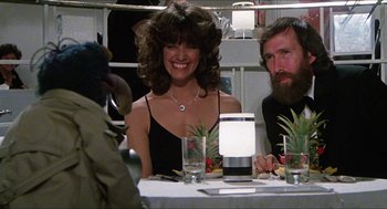 Movie still from “The Great Muppet Caper” (1981), directed by Jim Henson – A woman sitting at a dinner table with two men; Medium shot, Over the shoulder angle