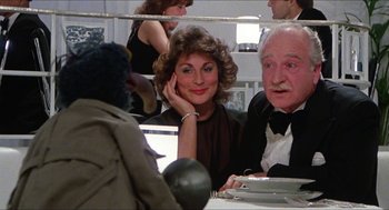 Movie still from “The Great Muppet Caper” (1981), directed by Jim Henson – A woman sitting next to an older man at a dinner table; Close Up shot, Over the shoulder angle
