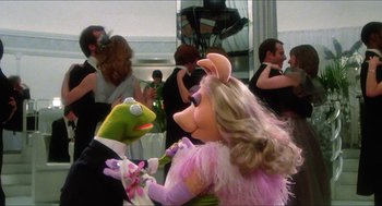 Movie still from “The Great Muppet Caper” (1981), directed by Jim Henson – A couple of people that are dressed like kermit the frog and miss piggy; Wide shot, High angle