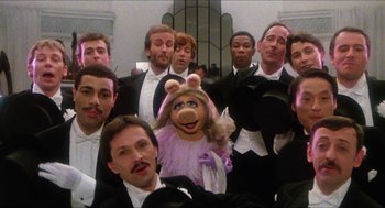 Movie still from “The Great Muppet Caper” (1981), directed by Jim Henson – A group of men in tuxedos posing for a picture with a muppet; Medium shot, High angle