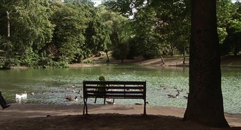 Movie still from “The Great Muppet Caper” (1981), directed by Jim Henson – A person sitting on a bench in front of a lake; Extreme Wide shot, High angle
