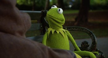 Movie still from “The Great Muppet Caper” (1981), directed by Jim Henson – A stuffed animal sitting on top of a wooden bench; Close Up shot, Over the shoulder angle