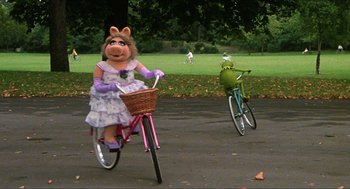 Movie still from “The Great Muppet Caper” (1981), directed by Jim Henson – A couple of people riding bikes in a park; Wide shot, High angle