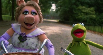 Movie still from “The Great Muppet Caper” (1981), directed by Jim Henson – A woman riding a bike next to kermit the frog; Close Up shot, High angle