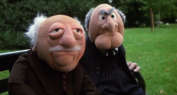 Movie still from “The Great Muppet Caper” (1981), directed by Jim Henson – A couple of people that are sitting next to each other; Medium shot, Low angle