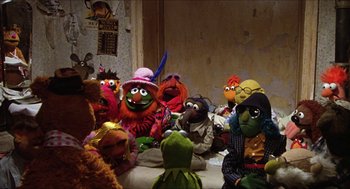 Movie still from “The Great Muppet Caper” (1981), directed by Jim Henson – A group of muppets sitting around a table; Wide shot, High angle