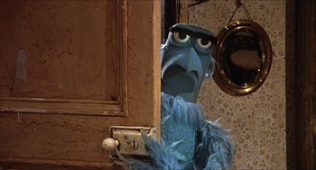 Movie still from “The Great Muppet Caper” (1981), directed by Jim Henson – A person with a stuffed animal in a room; Close Up shot, Low angle