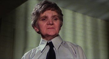 Movie still from “The Great Muppet Caper” (1981), directed by Jim Henson – An older woman wearing a white shirt and a black tie; Close Up shot, Low angle