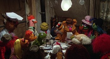 Movie still from “The Great Muppet Caper” (1981), directed by Jim Henson – A group of stuffed animals sitting on top of a wooden table; Wide shot, High angle