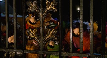 Movie still from “The Great Muppet Caper” (1981), directed by Jim Henson – A group of stuffed animals behind a metal fence; Medium shot, High angle
