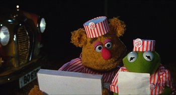 Movie still from “The Great Muppet Caper” (1981), directed by Jim Henson – A stuffed animal wearing a paper hat; Medium shot, Over the shoulder angle