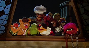 Movie still from “The Great Muppet Caper” (1981), directed by Jim Henson – A bunch of stuffed animals sitting on top of a table; Wide shot, High angle