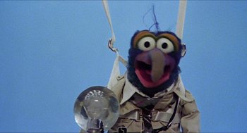 Movie still from “The Great Muppet Caper” (1981), directed by Jim Henson – A man in a military outfit holding a metal object; Close Up shot, Low angle