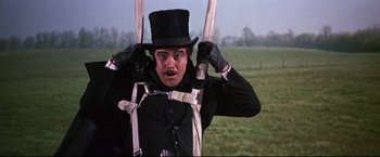 Movie still from “The Great Race” (1965), directed by Blake Edwards – A man in a top hat holding onto a harness; Medium shot, Low angle