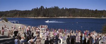 Movie still from “The Great Race” (1965), directed by Blake Edwards – A group of people standing around a body of water; Extreme Wide shot, High angle