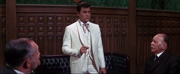 Movie still from “The Great Race” (1965), directed by Blake Edwards – A man in a white suit is pointing to the side; Medium shot, Low angle