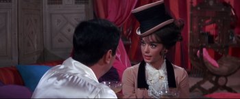 Movie still from “The Great Race” (1965), directed by Blake Edwards – A man and a woman sitting at a table talking to each other; Medium shot, Over the shoulder angle