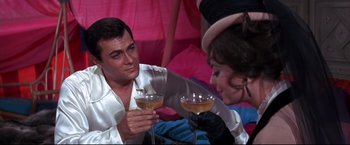 Movie still from “The Great Race” (1965), directed by Blake Edwards – A man and a woman holding glasses of wine; Medium shot, Over the shoulder angle