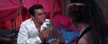 Movie still from “The Great Race” (1965), directed by Blake Edwards – A man and a woman sitting at a table holding wine glasses; Medium shot, Over the shoulder angle