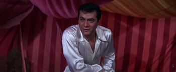 Movie still from “The Great Race” (1965), directed by Blake Edwards – A man in a white shirt is posing for a picture; Medium shot, Low angle