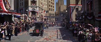 Movie still from “The Great Race” (1965), directed by Blake Edwards – An old fashioned car driving down a street; Extreme Wide shot, High angle