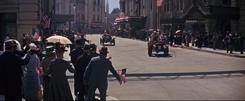 Movie still from “The Great Race” (1965), directed by Blake Edwards – A group of men in suits and hats riding down a street; Wide shot, High angle