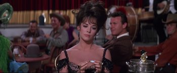Movie still from “The Great Race” (1965), directed by Blake Edwards – A woman in a black dress is holding a cigarette; Close Up shot, Over the shoulder angle