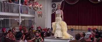 Movie still from “The Great Race” (1965), directed by Blake Edwards – A woman in a yellow dress on a runway; Wide shot, Low angle