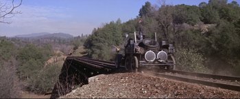 Movie still from “The Great Race” (1965), directed by Blake Edwards – An old train is traveling down the tracks; Extreme Wide shot, Low angle