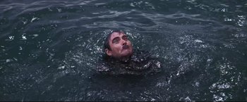 Movie still from “The Great Race” (1965), directed by Blake Edwards – A man in the water with a black mask on his face; Medium shot, High angle